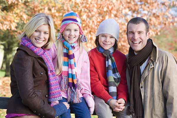 Family sitting on a fence on an autumn walk